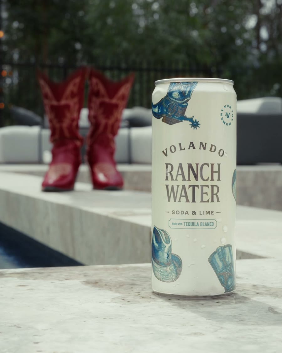 A can of Volando Ranch Water by the pool, with red cowboy boots